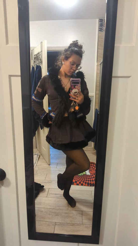 Mirror outfit photo with a black skirt, sheer-look leggings and tall black boots